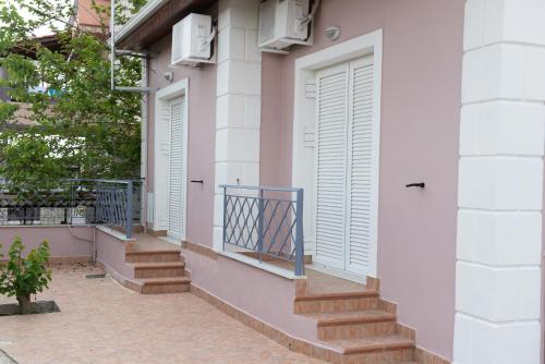 a building with two doors and stairs on it at Patras Cozy Lodge in Patra