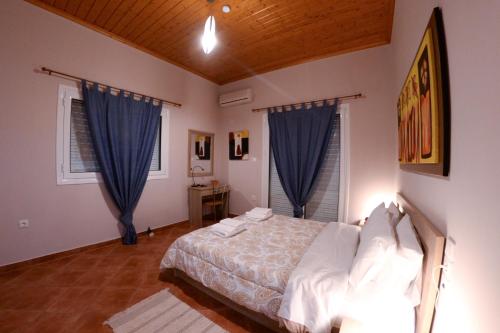 a bedroom with a bed and blue curtains at Patras Cozy Lodge in Patra