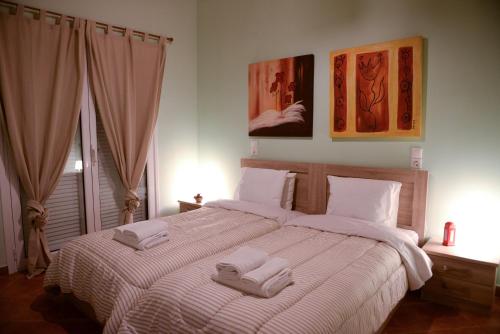 a bedroom with a large bed with two towels on it at Patras Cozy Lodge in Patra