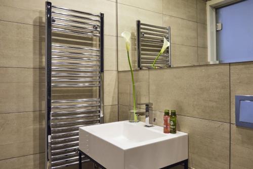 a bathroom with a sink and a vase with a flower at Boca Boutique Hotel in Timişoara