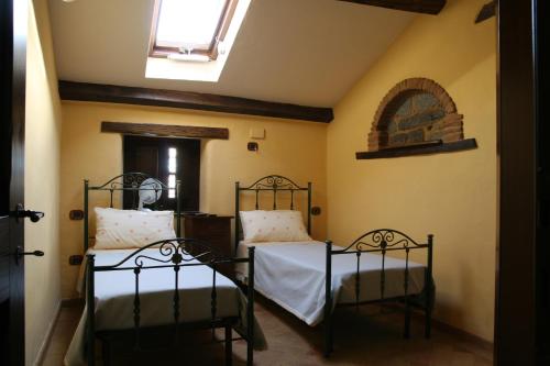 zwei Betten in einem Zimmer mit Fenster in der Unterkunft Antico Restauro in Fonni