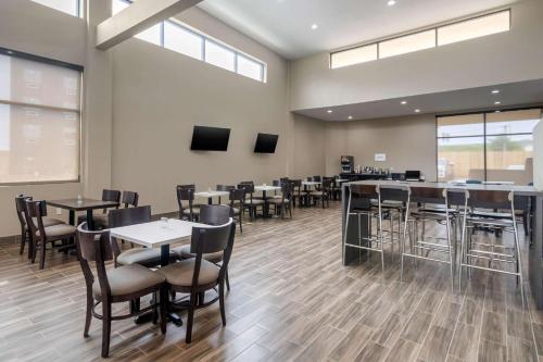 a dining room with tables and chairs and windows at Sleep Inn & Suites Bricktown - near Medical Center in Oklahoma City