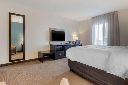 a hotel room with a large bed and a television at Sleep Inn & Suites Bricktown - near Medical Center in Oklahoma City