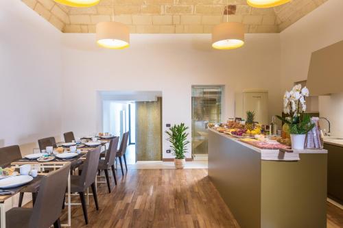 een restaurant met lange tafels en stoelen en een bar bij Dimora dei Salentini in Lecce