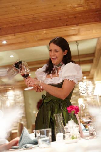 a woman in a green dress holding a wine glass at Hotel Alpin Spa Tuxerhof in Tux