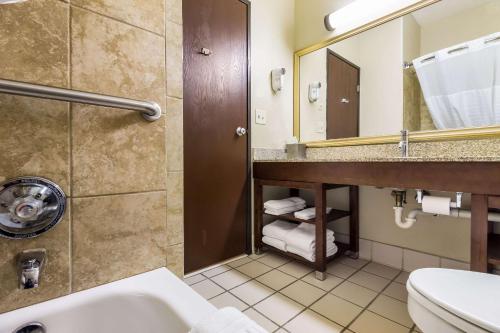 a bathroom with a sink and a toilet and a mirror at Comfort Suites in Sioux Falls