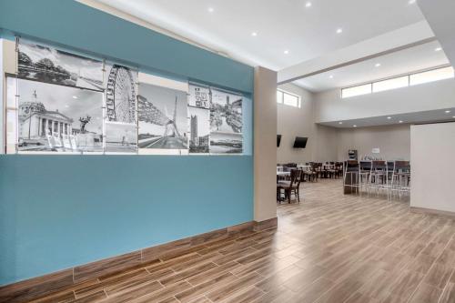 a large room with a blue wall with photographs on the wall at MainStay Suites Bricktown - near Medical Center in Oklahoma City