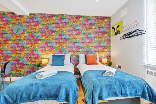 - 2 lits dans une chambre dotée d'un mur coloré dans l'établissement Rainbow Studio - By My Getaways, à Brighton et Hove