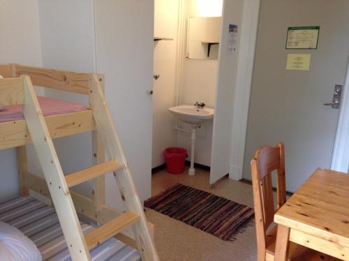 ein kleines Zimmer mit einem Etagenbett und einem Waschbecken in der Unterkunft Ronneby Brunnspark Vandrarhem och B&B in Ronneby