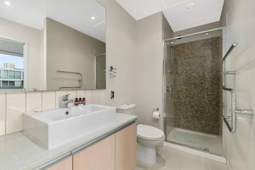 La salle de bains est pourvue d'un lavabo, de toilettes et d'une douche. dans l'établissement Two Bedroom Apartment - Pool, Gym & Free Parking!, à Auckland
