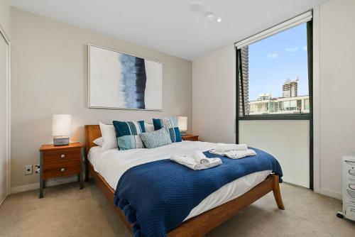 - une chambre avec un grand lit et une fenêtre dans l'établissement Two Bedroom Apartment - Pool, Gym & Free Parking!, à Auckland