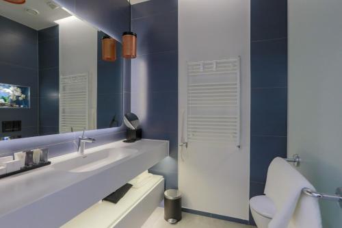 a bathroom with a sink and a toilet and a mirror at Jurmala Golf Club&Hotel in Piņķi