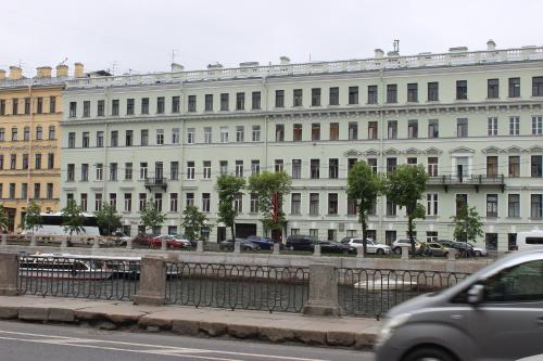 a large white building with cars parked in front of it at Rinaldi Art in Saint Petersburg