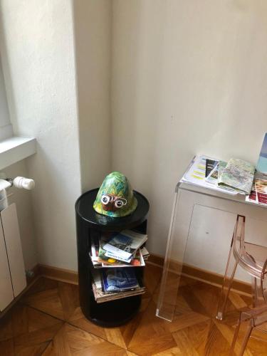 a hat sitting on top of a trash can next to a table at Alla Scalinata del Teatro Rossetti parcheggio in Trieste
