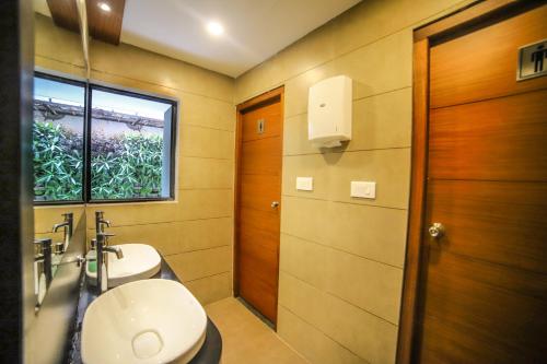a bathroom with a toilet and a sink and a window at Hotel Villa Maryam in Kozhikode