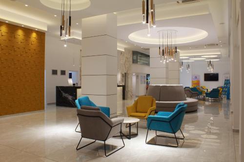 a lobby with chairs and couches in a building at Kapetanios Bay Hotel Protaras in Protaras