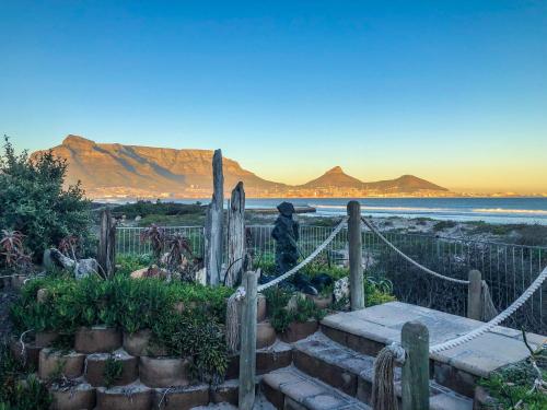 a large stone wall with a view of mountains at Cape Town Beachfront Apartments at Leisure Bay in Cape Town