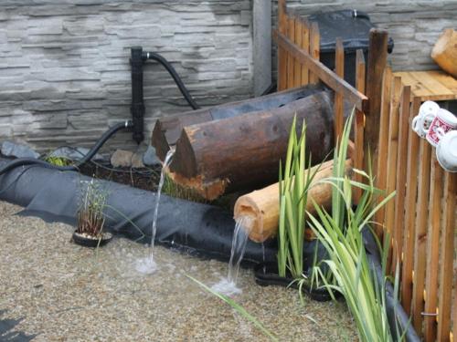a water fountain in a yard next to a fence at Srub Losiny in Velké Losiny