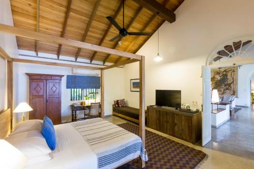 1 dormitorio con 1 cama grande y TV en Villa Saffron Hikkaduwa en Hikkaduwa