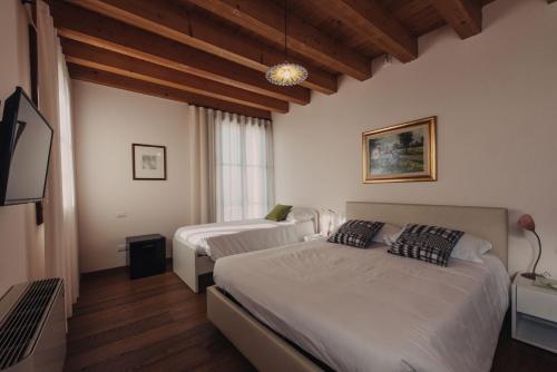 Sarcedo的住宿－La Costa，酒店客房设有两张床和电视。