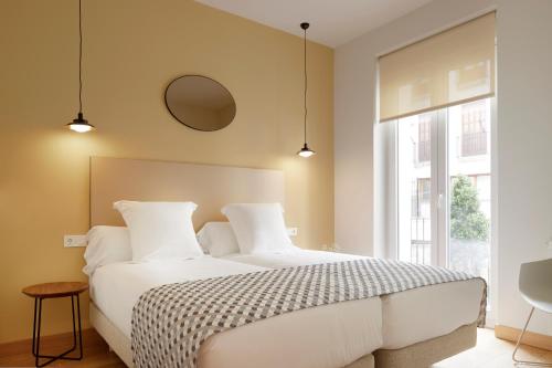 una camera con un letto bianco e una grande finestra di Eguzki by FeelFree Rentals a San Sebastián