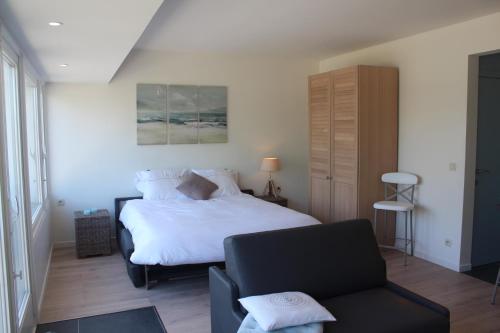 オーステンデにあるStudio Azur Oostendeのベッドルーム(白いベッド1台、椅子付)