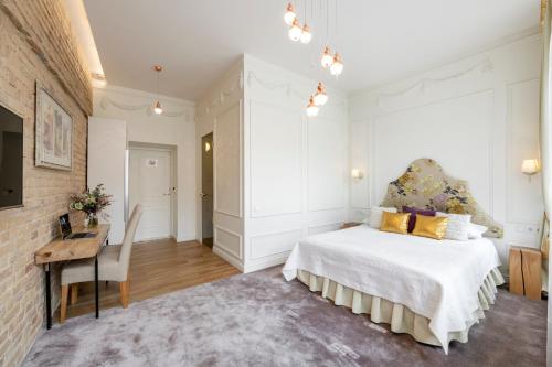 a bedroom with a white bed and a desk and a chair at Stepono apartments in Vilnius