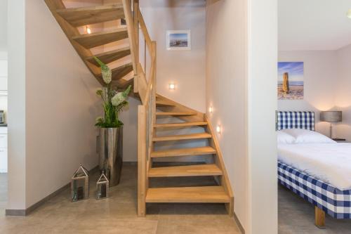 a staircase leading up to a bedroom with a bed at Haus Charlotte in Zingst