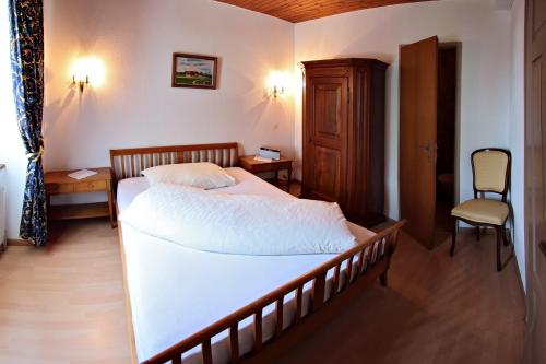 a bedroom with a large bed and a chair at Gasthof National in Langendorf