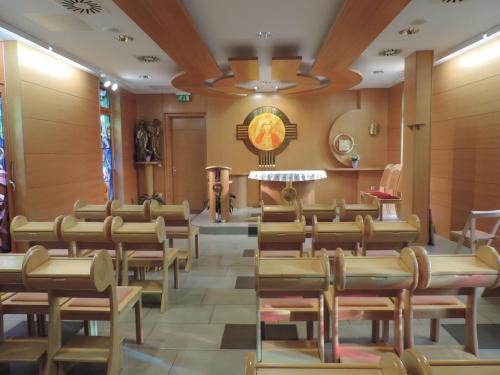 uma igreja com cadeiras e uma mesa em uma sala em Marijin dom - Retreat House em Bled