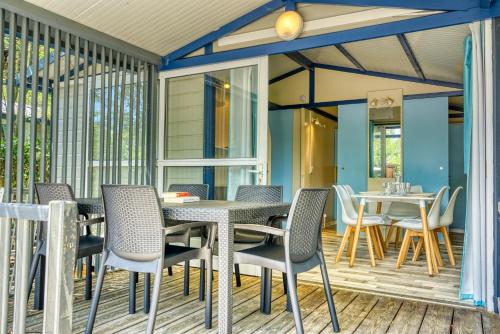 a patio with a table and chairs on a deck at Camping Resort Les Champs Blancs in Agde