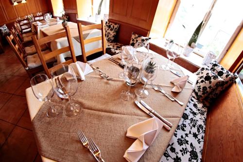 a table with wine glasses and napkins on it at Gasthof National in Langendorf