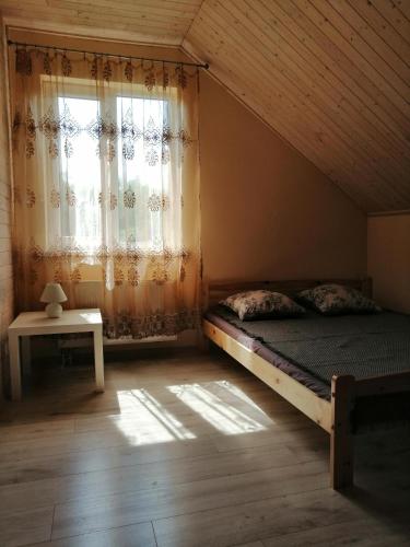 a bedroom with a bed and a window with curtains at Igor House in Jūrmala