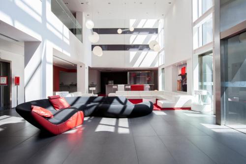 ein großes Wohnzimmer mit einem schwarzen und roten Sofa in der Unterkunft Axor Feria in Madrid