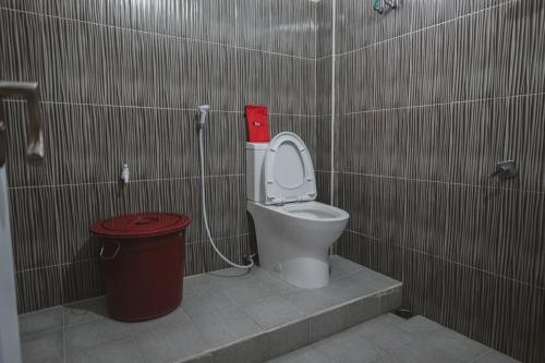 a bathroom with a toilet and a trash can at RedDoorz Syariah @ Jalan Dieng in Wonosobo