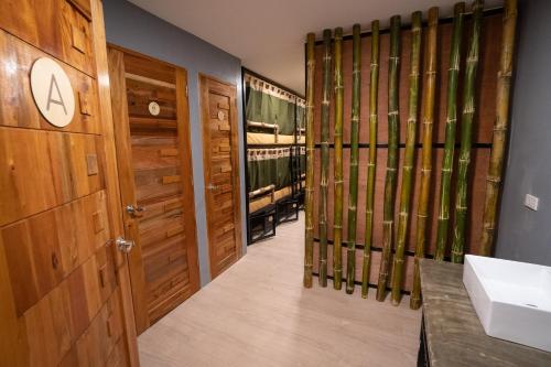 a bathroom with a sink and a bathroom with wooden doors at BAMBAM Hostel in Coron
