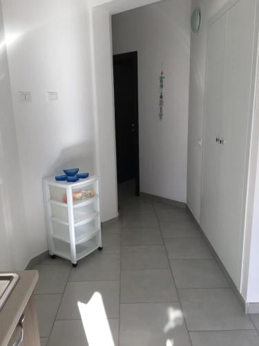 a white room with a white cabinet and a hallway at Casa Regina in Castelluzzo
