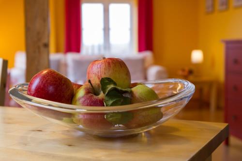 a glass bowl of apples and pears on a table at Vogelhaus Gobbin in Lancken-Granitz