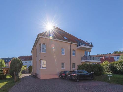 una casa con il sole che splende sopra di essa di Apartmenthaus am Seeufer a Waren