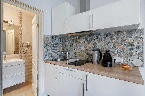 a kitchen with white cabinets and a sink at Stepono apartments in Vilnius