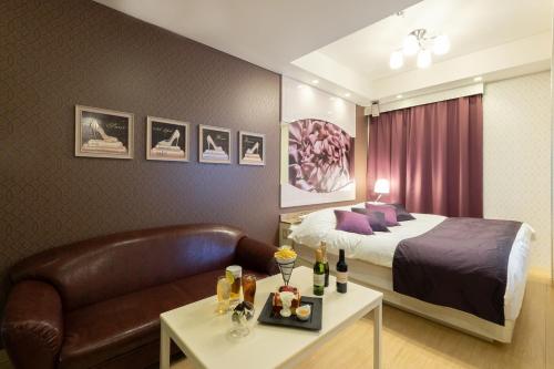 a hotel room with a bed and a couch at ホテル マイン 岐阜 in Ginan