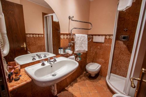 a bathroom with a sink and a toilet and a shower at Albergo Le Due Corti in Como