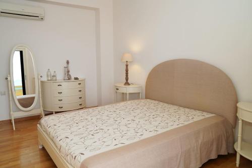 a bedroom with a bed and a dresser and a mirror at Casa Minervos in Áptera