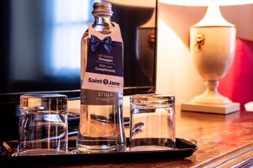 a bottle of water and two glasses on a table at Albergo Le Due Corti in Como