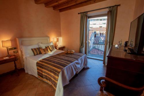 a bedroom with a bed and a large window at Albergo Le Due Corti in Como