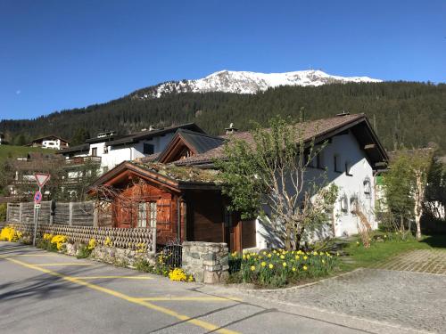 uma casa ao lado de uma rua com uma montanha em Studio in Klosters em Klosters