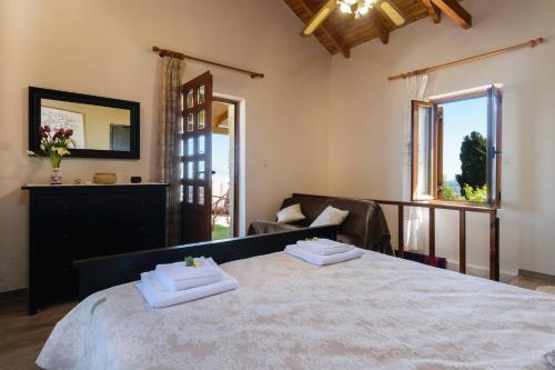 Casa Vasilia Traditional Home في Kástellos: غرفة نوم بسرير كبير عليها منشفتين