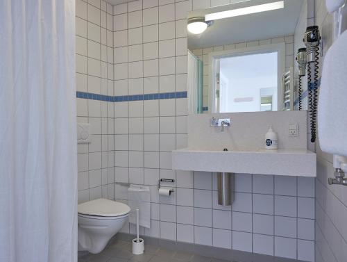 y baño con aseo, lavabo y espejo. en BB-Hotel Aarhus Havnehotellet, en Aarhus
