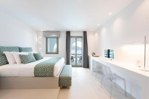 a bedroom with a bed and a desk with a chair at Hotel Senia - Onar Hotels Collection in Naousa