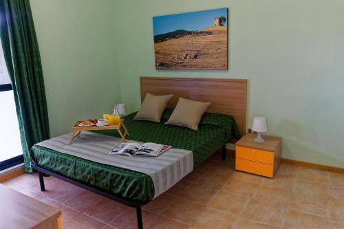 Un dormitorio con una cama y una mesa con revistas. en Residence Habitat, en Marina di Bibbona